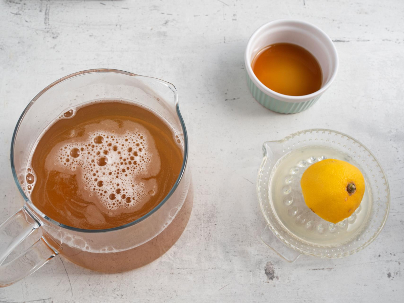 Zaparzona herbata w dzbanku. Obok cytryna oraz miód.