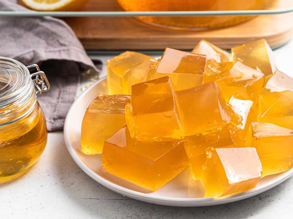 Zbliżenie na kolagenowe żelki z zieloną herbatą pokrojone w kostkę na talerzyku - przepis Wszystkiego Słodkiego