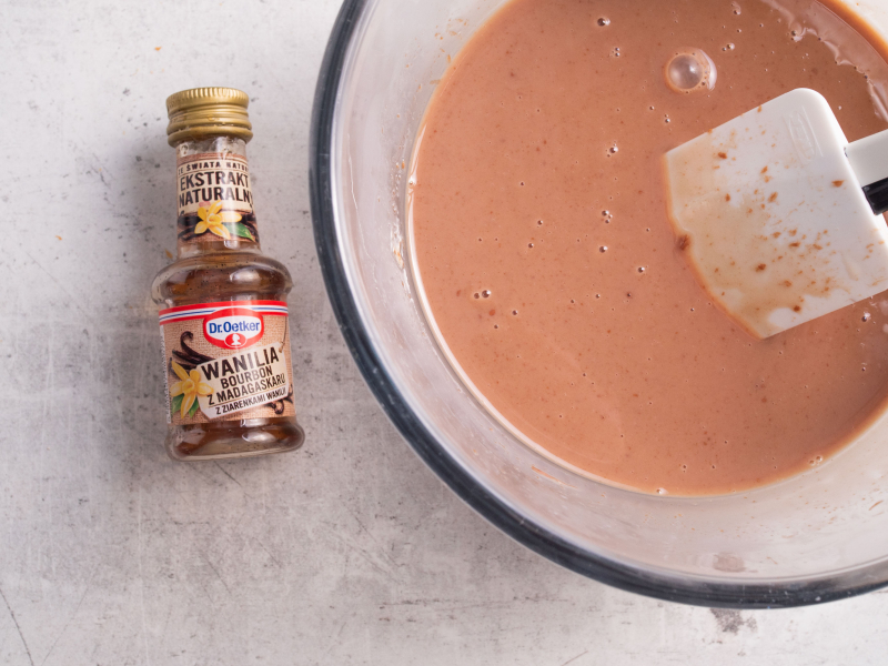 czekolady rozpuszczone w śmietance, obok ekstrakt z wanilii