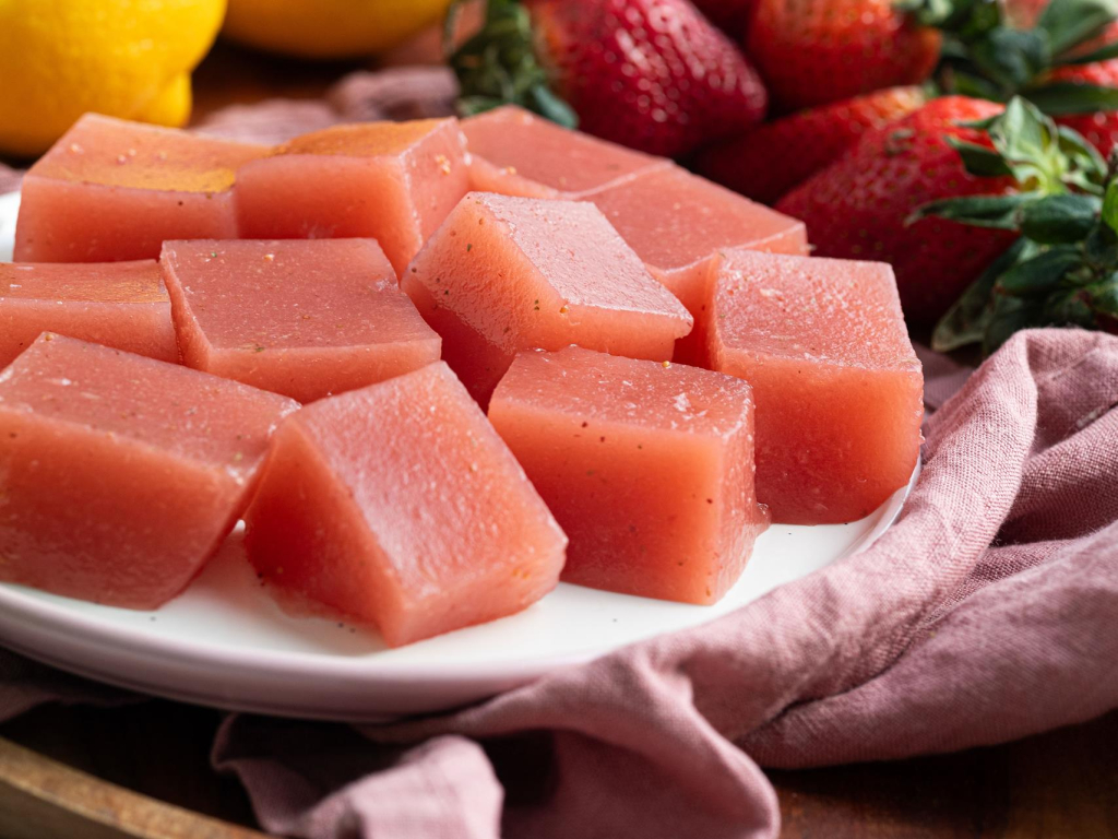 Truskawkowe żelki kolagenowe pokrojone w kostkę na talerzyku - przepis Wszystkiego Słodkiego