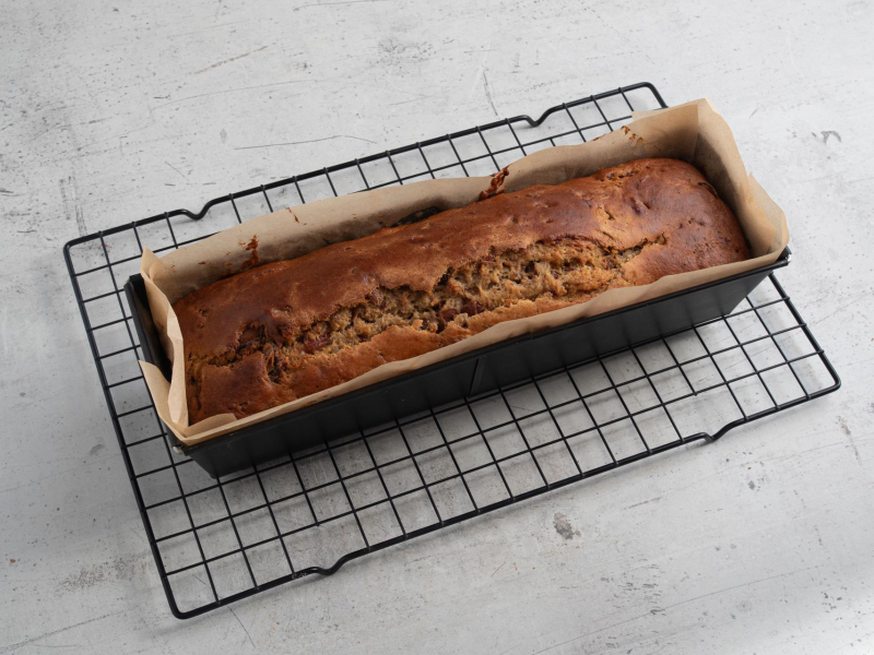 Upieczony chlebek daktylowy w formie studzący się na kratce.