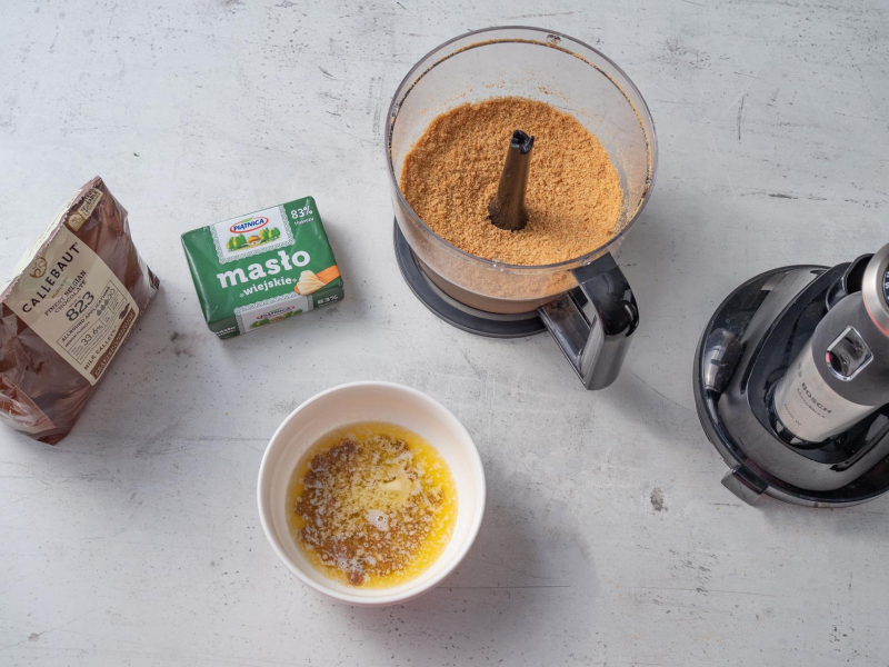 pokruszone ciasteczka w malakserze i rozpuszczone masło z czekoladą w miseczce