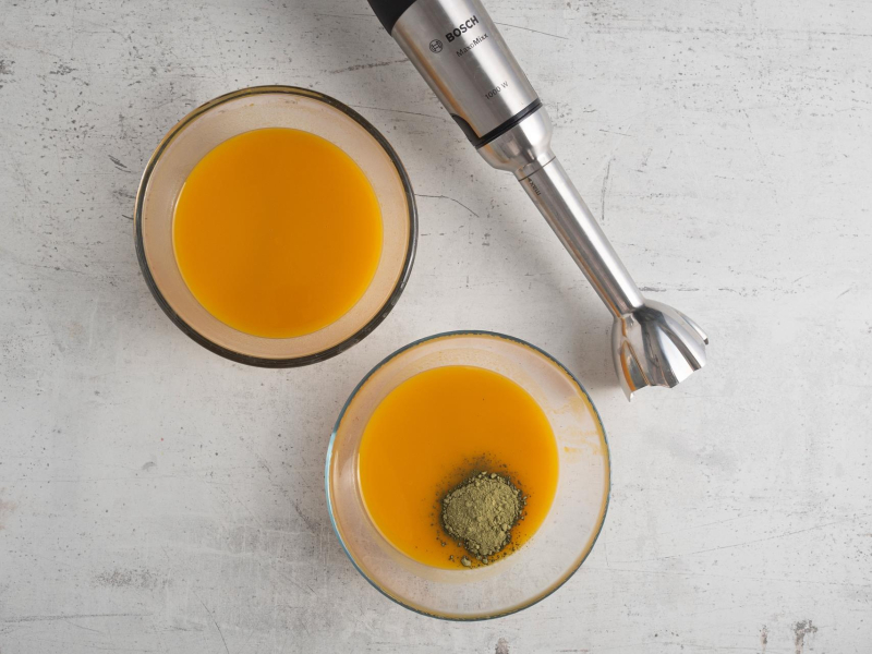 Dwie szklane miski z pulpą mango z żelatyną. Jedna z dodatkiem herbaty matcha.