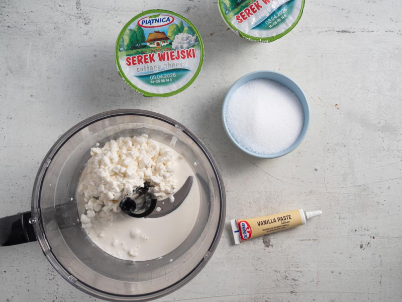 Na blacie kuchennym opakowanie malaksera z serkiem wiejskim. Obok erytrytol w miseczce i pasta z waniliii.