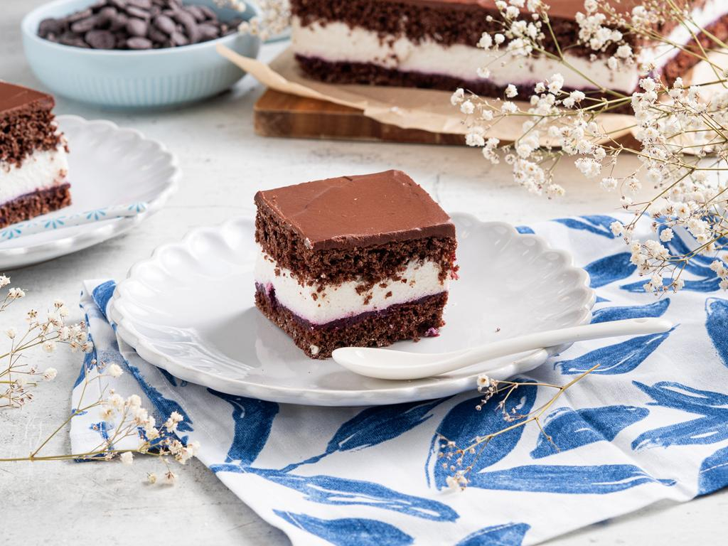 Kawałek fit wuzetki z kremem z serka wiejskiego i polewą czekoladową na białym talerzyku - przepis Wszystkiego Słodkiego