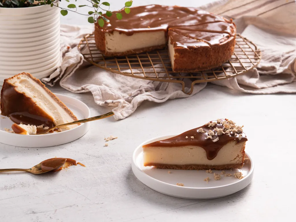 sernik z serków śmietankowych z polewą karmelową z miso i tahini, posypany chałwą