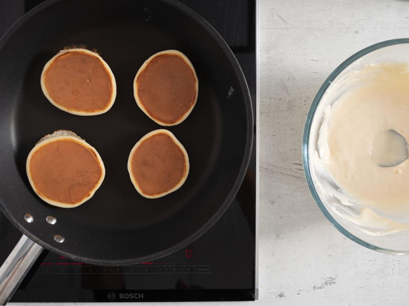 Usmażone pancakes na patelni, a obok ciasto w misie.