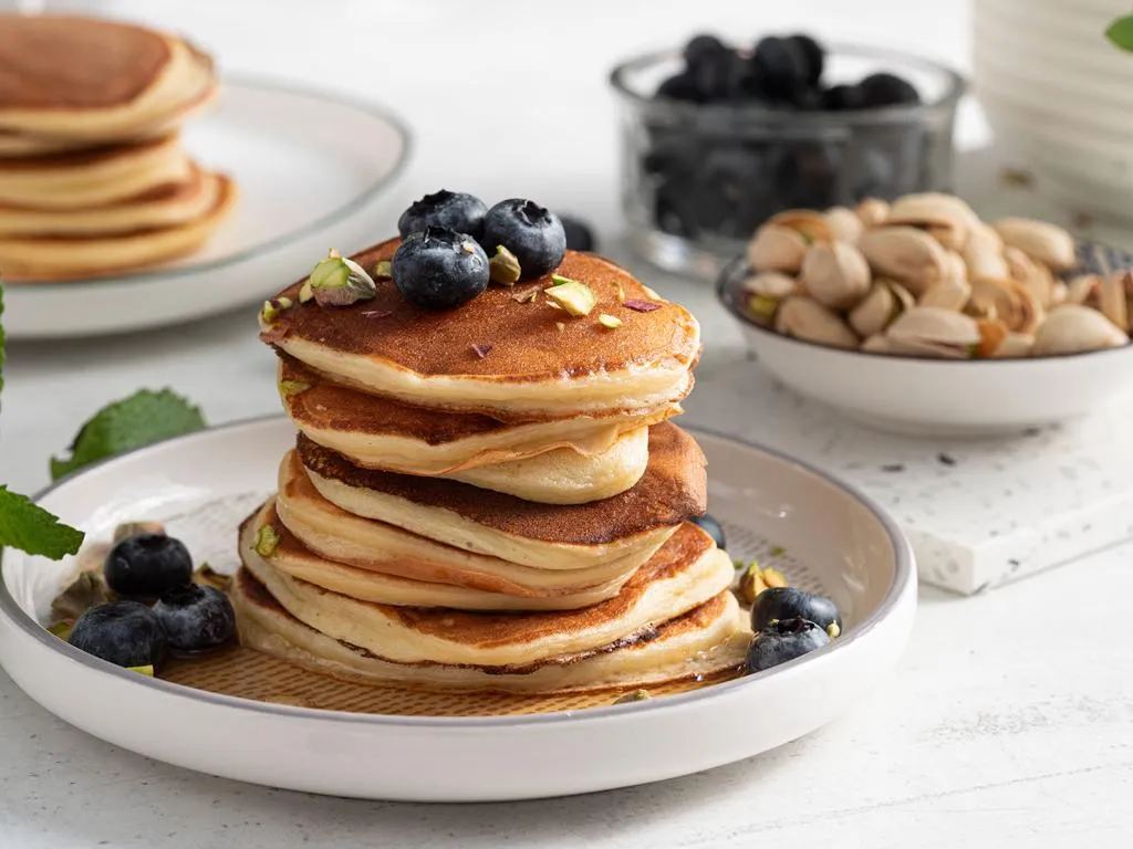 Pancakes ze skyrem polane syropem klonowym, podane z borówkami i pistacjami - przepis Wszystkiego Słodkiego