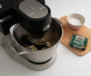 Ucieranie masła z cukrem pudrem w robocie kuchennym.