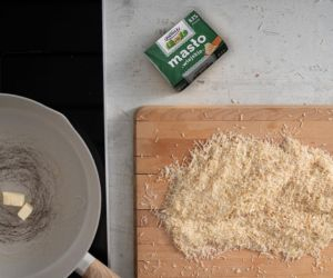 Ciasto kataifi na drewnianym blacie. Obok patelnia i masło.