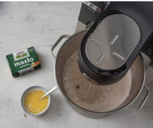 w misie ubijane ciasto na biszkopt obok rozpuszczone masło