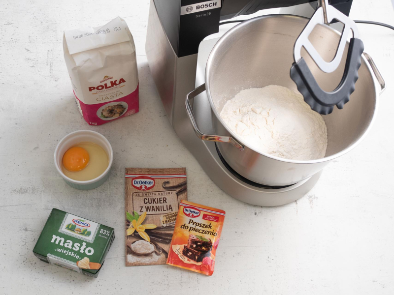 Na blacie kuchennym składniki do przygotowania kruchego spodu do ciasta kruchego z wiśniami.