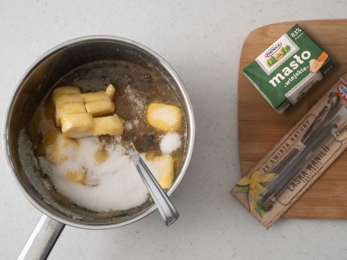 rondelek z miodem, masłem i cukrem obok deska drewniana z masłem i laską wanilii Dr. Oetkera