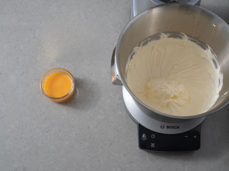 na blacie robot z ucieranym masłem w miseczce jajka