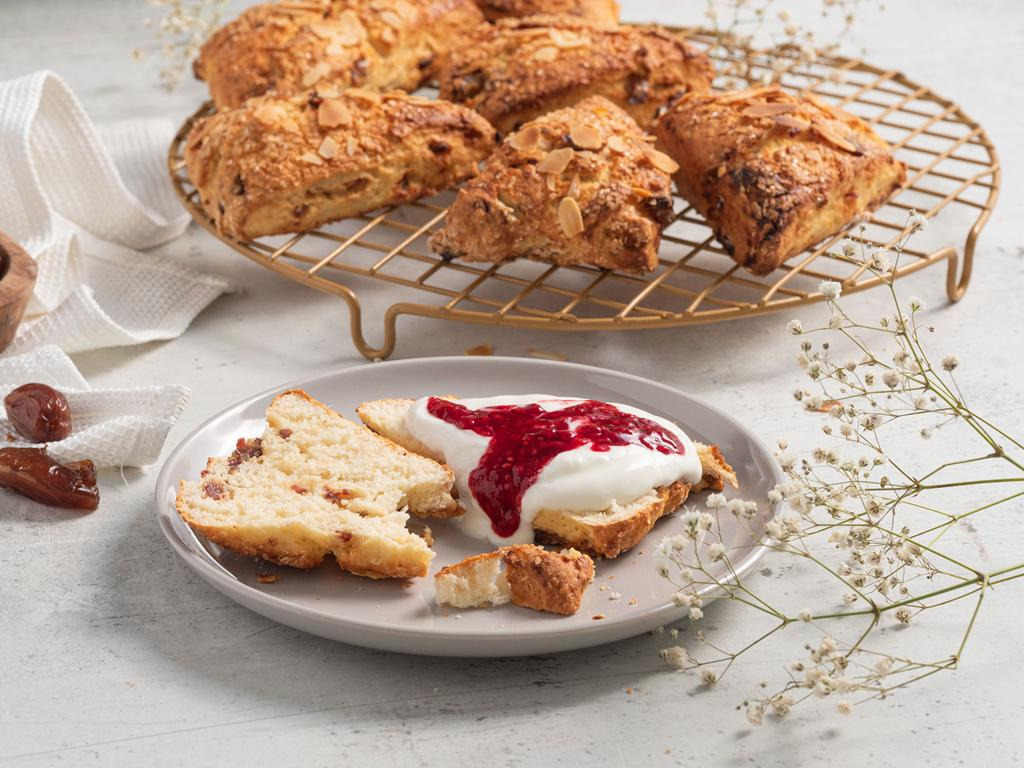 Bułeczki scones z serka wiejskiego podane z jogurtem i dżemem malinowym na talerzyku - przepis
