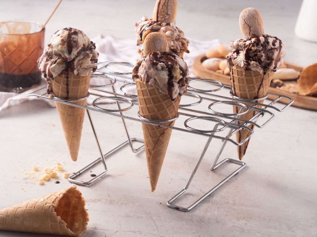 lody tiramisu w wafelkach, oblane syropem kawowym, na stojaku na lody