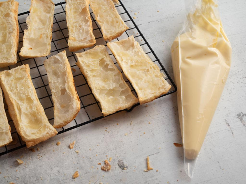Na kratce do pieczenia przekrojone kawałki upieczone ciasta francuskiego.