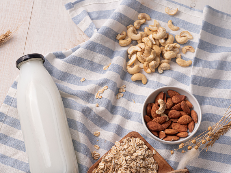 napój roślinny, obok nerkowce, migdały i płatki owsiane