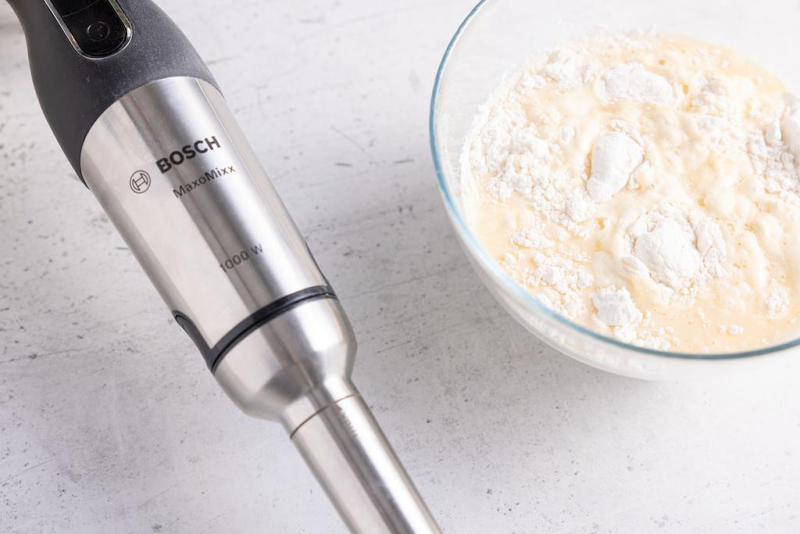 Wymieszane składniki na pancakes. Obok blender ręczny.