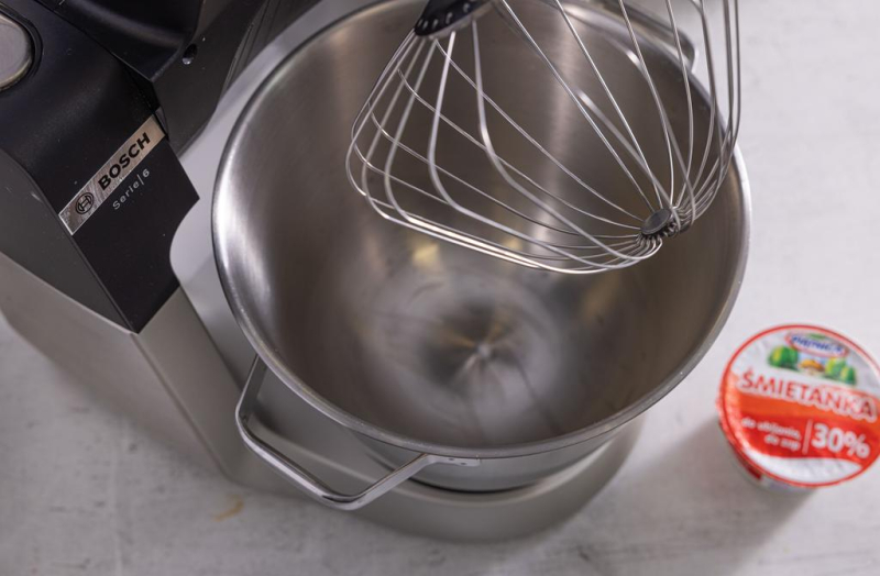 Robot kuchenny firmy Bosch na blacie kuchennym,. Obok śmietanka 30%.