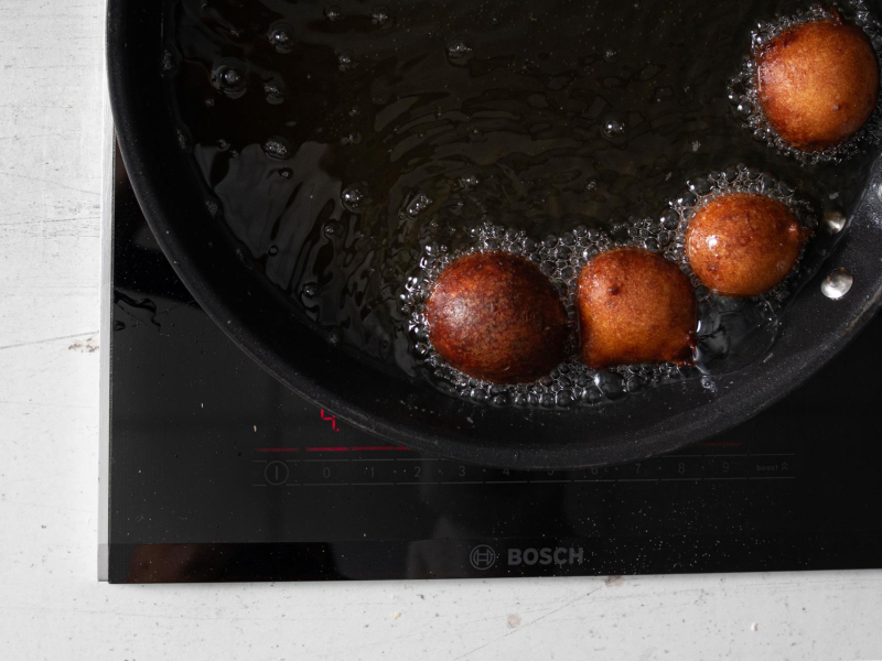 Smażenie mini pączków ze skyru na patelni,