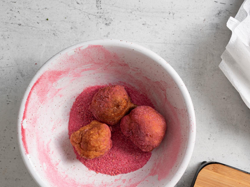 Mini pączki obtoczone w owocowym cukrze pudrze.