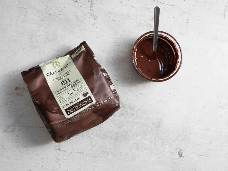 Opakowanie czekolady oraz rozpuszczona czekolada w miseczce.