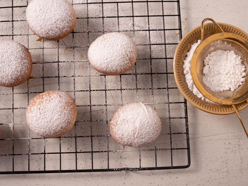 pączki z airfryera na kratce do studzenia posypane cukrem pudrem