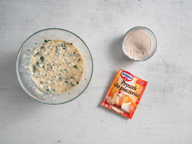 W misce masa na pancakes z serka wiejskiego, a obok mąka orkiszowa oraz opakowanie proszku do pieczenia.