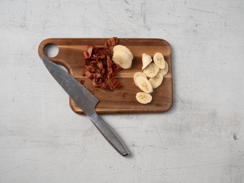 na deseczce pokrojony poczek i plastry bananów