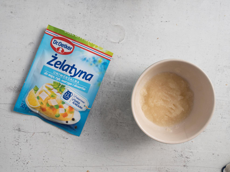Żelatyna ma blacie kuchennym. Obok żelatyna w miseczce.
