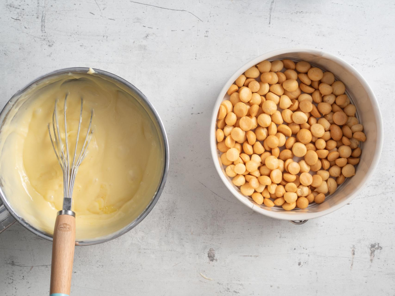 W formie rozłożony groszek ptysiowy. Obok ugotowany budyń w garnku.