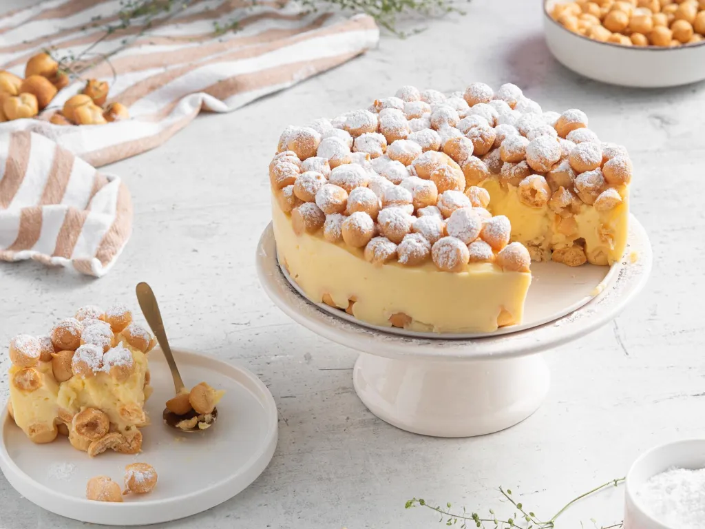 Karpatka z groszku ptysiowego obsypana cukrem cukrem. Jeden kawałek karpatki na talerzyku - przepis Wszystkiego Słodkiego